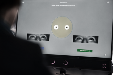 A person seen from behind sits at an eye tracker