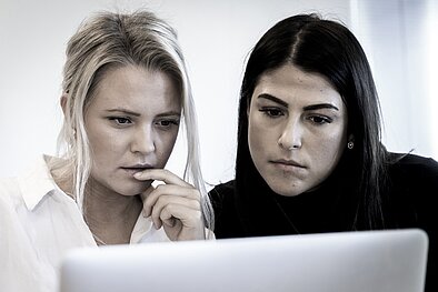 Two people are looking at a computer screen