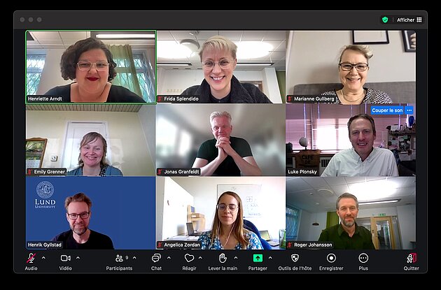 A screen grab of a Zoom room with nine participants. Everyone is smiling at the camera.